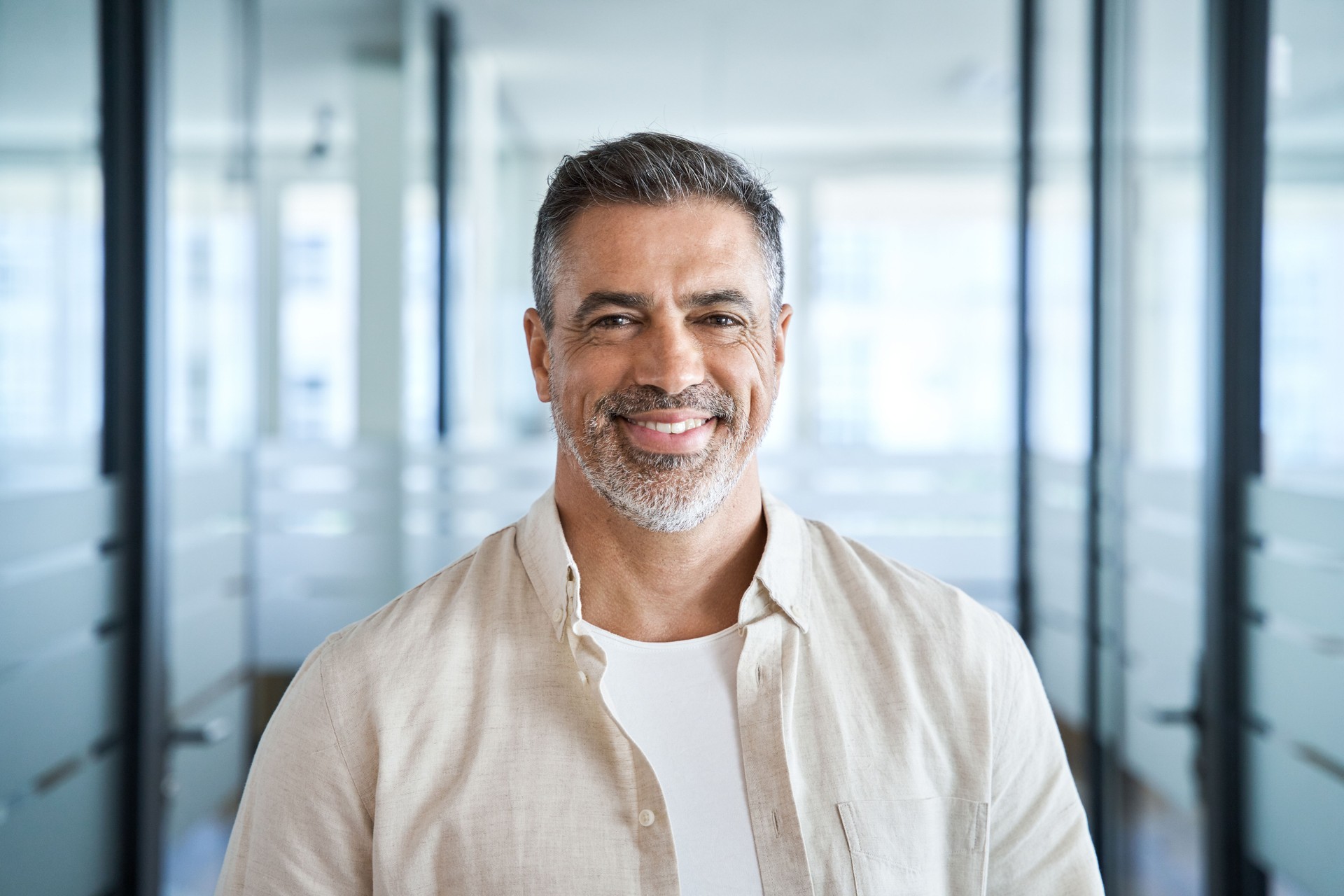 Headshot portrait of confident handsome mature middle age businessman at office