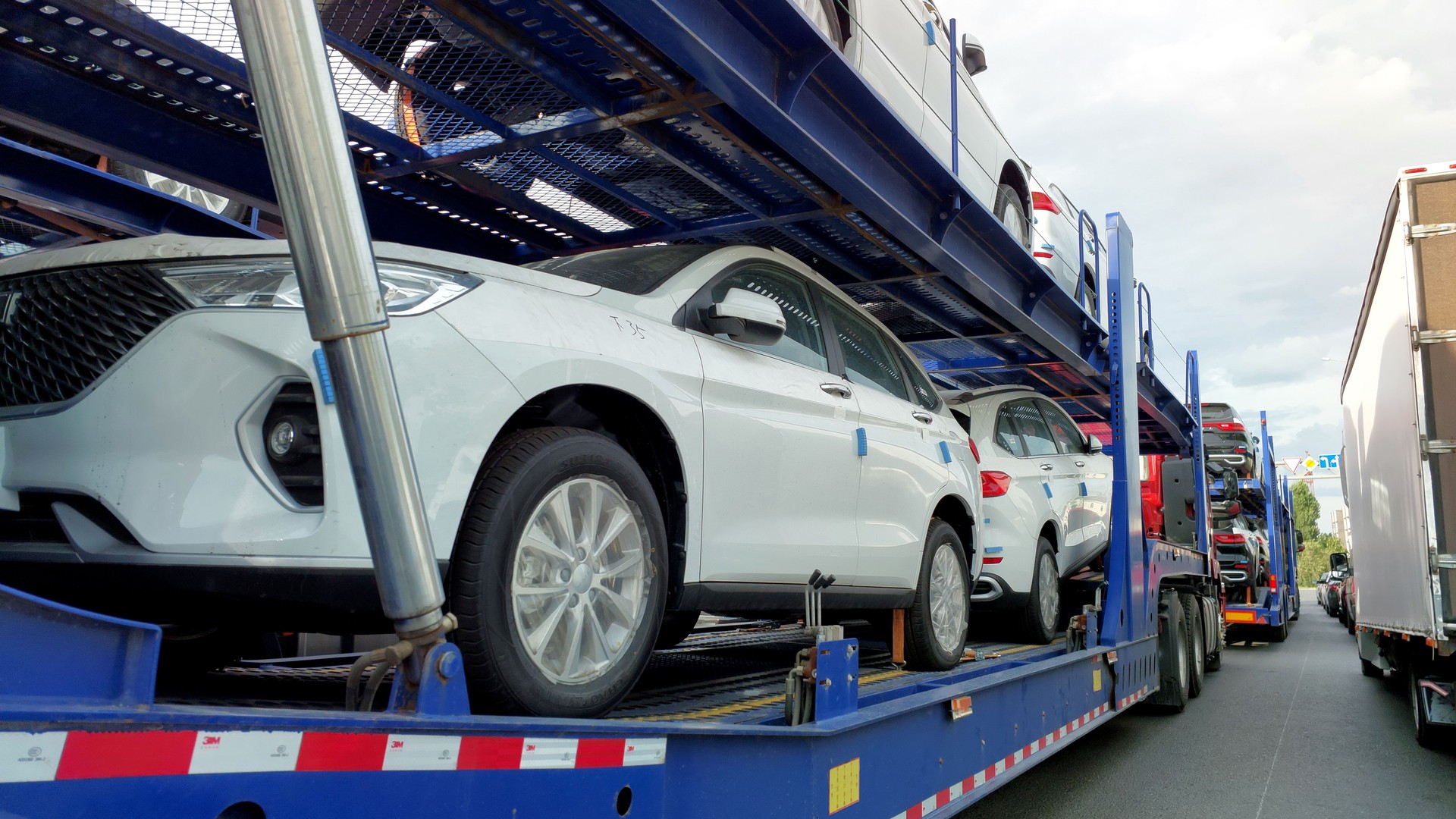 Car transporters loaded with Chinese cars. Car transporters transport new cars